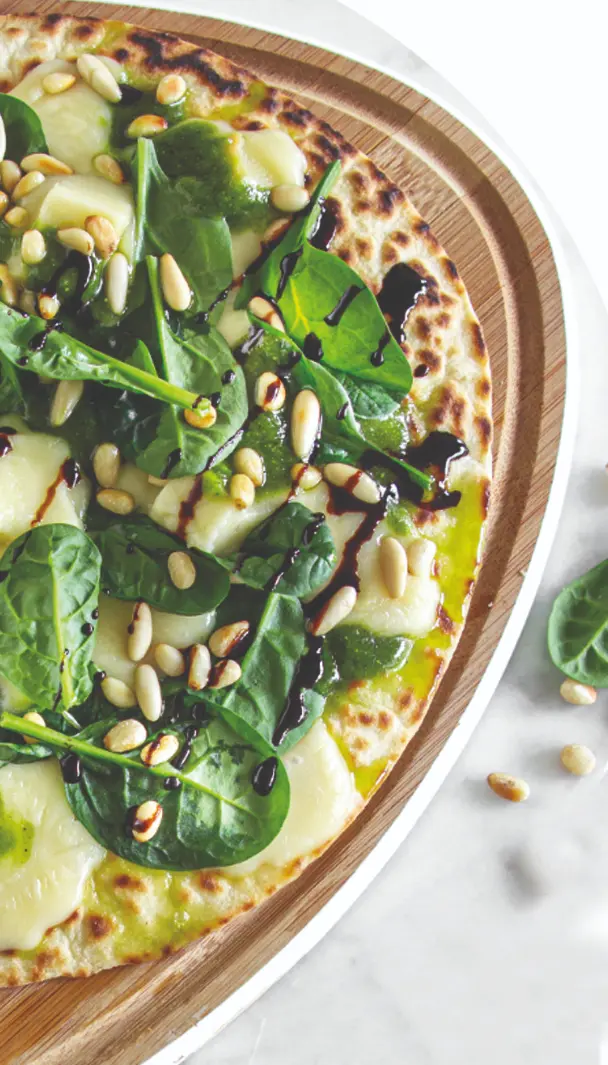 Piadina con spinaci freschi, formaggio, pinoli e un filo di olio extravergine d'oliva, completata con una spruzzata di aceto balsamico.