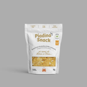 Piadina Snack ai semi di lino e chia, presentata in una confezione da 70g. La busta evidenzia che il prodotto è fatto con piadina fritta croccante, senza lievito e conservanti, e arricchita con semi di lino e chia per un gusto sano e gustoso.